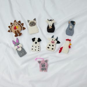 May include: Set of ten felt finger puppets featuring various farm animals, including a turkey, sheep, goat, mouse, rabbit, dalmatian dog, cow, rooster, and pig. The puppets are all hand-crafted and have a variety of colors and textures.