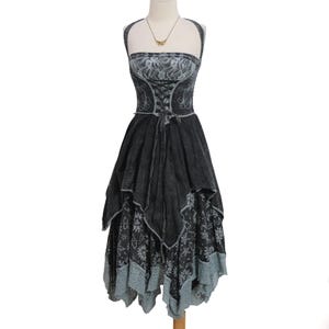 May include: A charcoal gray halter dress featuring a lace bodice with a corset-style lace-up front, a layered handkerchief hemline, and a skirt patterned with celestial motifs including suns, moons, and stars, finished with a light gray lace trim.