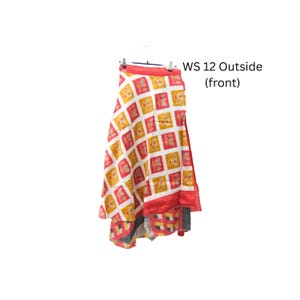 Op de afbeelding: Een rok met een herhalend ruitpatroon van witte, rode en gele vierkanten met bloemmotieven. Het kledingstuk hangt aan een hanger en bevat de tekst WS 12 Outside (front) gedrukt aan de rechterkant van de afbeelding.