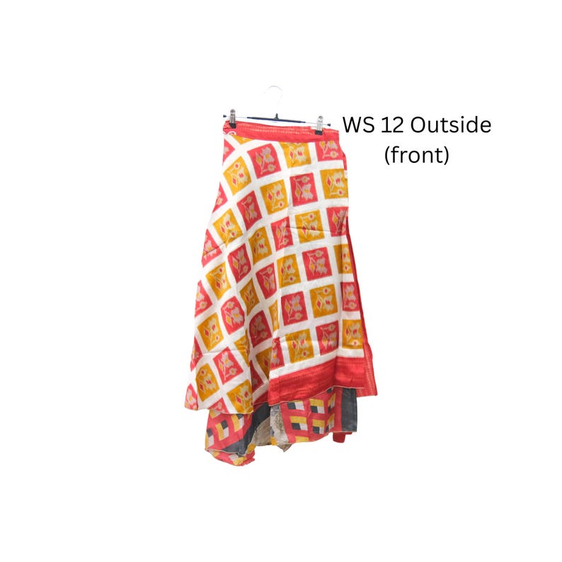 Op de afbeelding: Een rok met een herhalend ruitpatroon van witte, rode en gele vierkanten met bloemmotieven. Het kledingstuk hangt aan een hanger en bevat de tekst WS 12 Outside (front) gedrukt aan de rechterkant van de afbeelding.