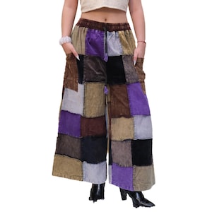 May include: Wide-leg trousers featuring a patchwork design made of corduroy fabric in shades of purple, brown, black, and light grey. The trousers have an elasticated waistband with a drawstring, two side pockets, and a loose, flowing silhouette.