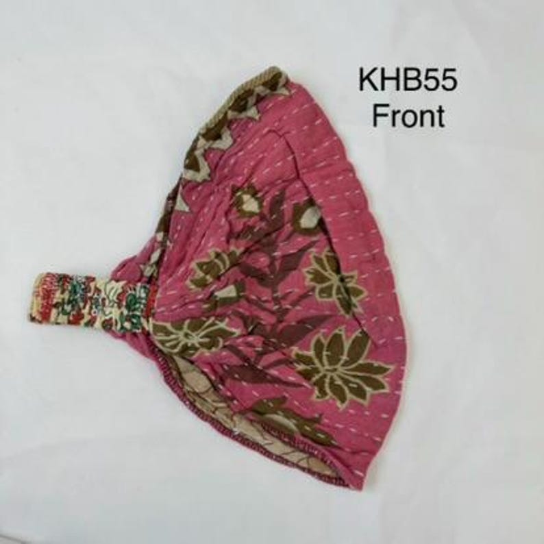 May include: A pink fabric headband featuring a brown floral pattern and white stitched detailing. The headband has an elasticized section with a multi-colored floral print. The text KHB55 Front is visible in the upper right corner of the image.
