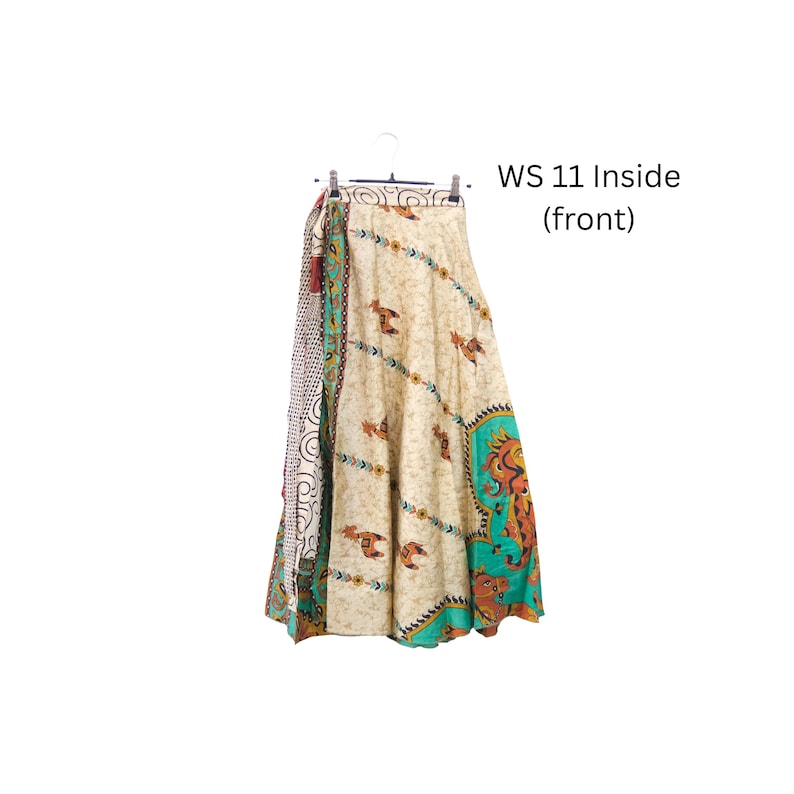 Op de afbeelding: Een lange wikkelrok aan een kledinghanger met een cr&egrave;mekleurige basis, bruine diermotieven en diagonale bloemenbanden. Het zijpaneel heeft een zwart-wit stippenpatroon en de tekst WS 11 Inside (front) is op de afbeelding te zien.