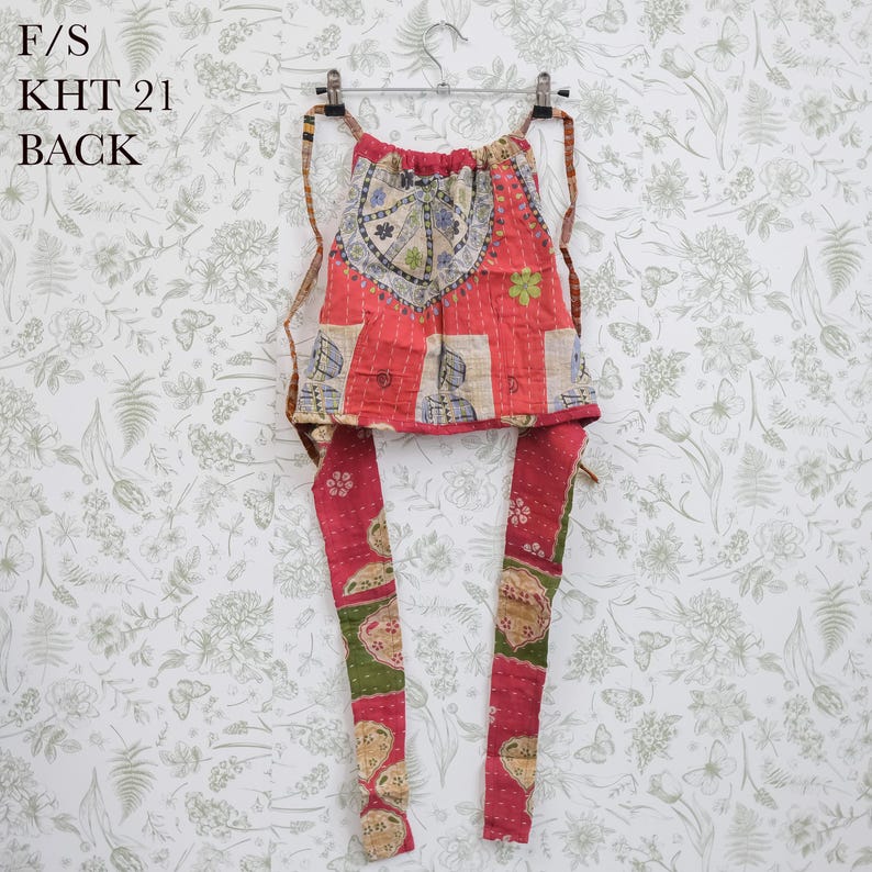 May include: A red drawstring bag featuring a patchwork design with floral and geometric patterns in green, blue, and cream. The bag has two long fabric straps and displays the text F/S KHT 21 BACK in the upper left corner of the image.