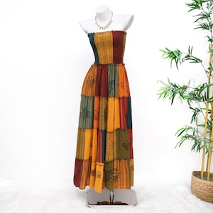 May include: A strapless maxi dress featuring a smocked bodice and a tiered skirt. The garment is constructed from vertical panels in shades of mustard yellow, deep red, and dark teal, accented with black butterfly and floral line art prints.