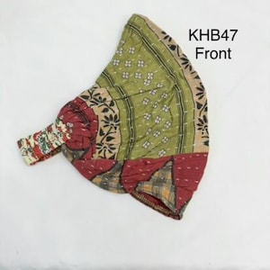 May include: A fabric headband featuring a patchwork design in shades of olive green, deep red, and tan with floral and geometric patterns. The accessory includes an elasticized band for fit and is labeled with the text KHB47 Front in the upper corner.
