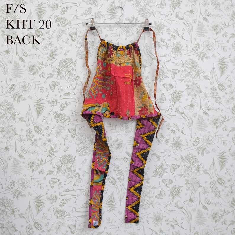 May include: A halter top featuring a patchwork design with vibrant red, yellow, and purple floral and geometric patterns. The garment includes thin fabric ties at the neck and waist, with visible kantha-style stitching throughout the fabric.