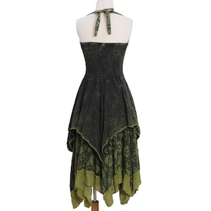 May include: A dark charcoal gray and olive green halter dress featuring a smocked bodice and a tie-neck closure. The skirt has an asymmetrical handkerchief hemline with a layered design, showcasing a sun, moon, and star print on the lower panel.