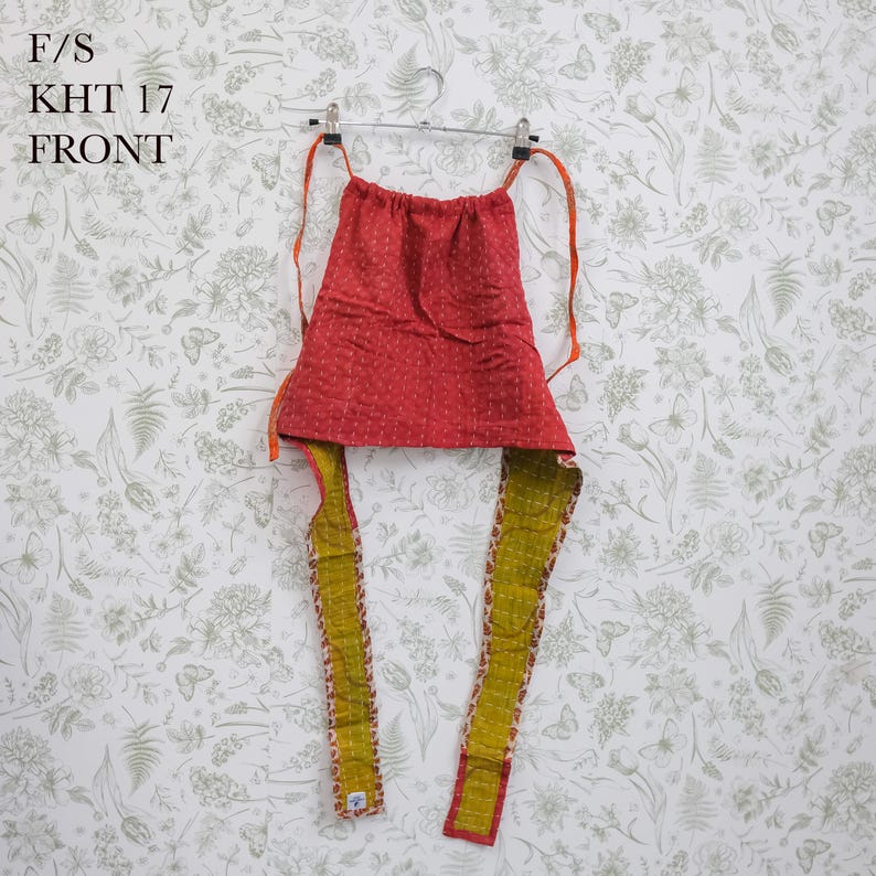 May include: A red quilted fabric top with a subtle white pattern and long olive green straps. The garment features a gathered neckline and is suspended from a metal hanger. Text in the upper left corner reads F/S KHT 17 FRONT.