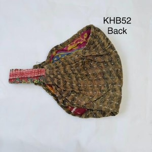 May include: A fabric headband featuring a brown exterior with a black wave pattern and white stitched detailing. The interior lining displays a colorful floral print in pink, yellow, and blue. The text KHB52 Back is visible in the upper right corner.