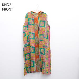 May include: A sleeveless, patterned garment with a square pattern in pink, green, and yellow. The garment has an orange center panel with a floral design and is labeled "KHD2 FRONT". It hangs on a hanger.