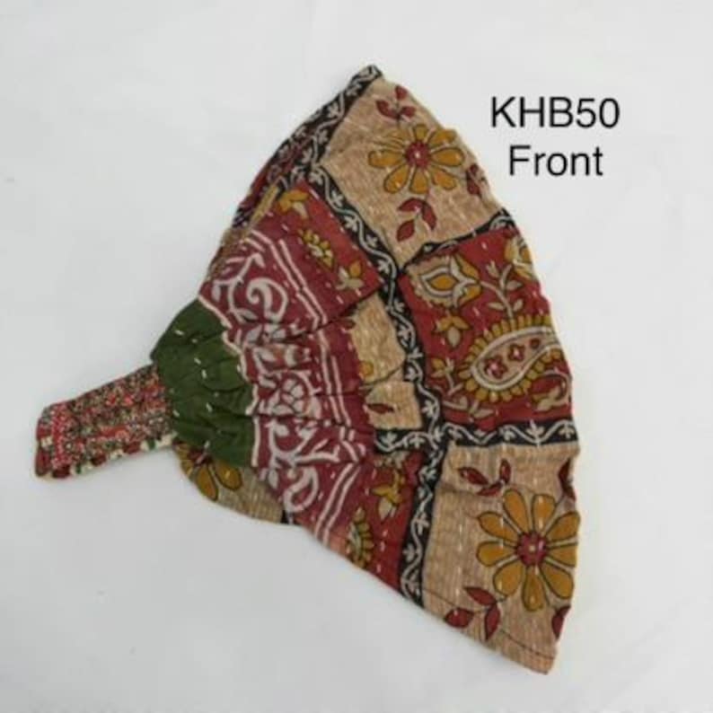 May include: A fabric headband featuring a patchwork design with floral and paisley patterns in shades of tan, red, green, and black. The accessory includes an elasticized back section and is labeled with the text KHB50 Front.