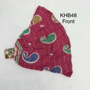May include: A magenta fabric headband featuring a repeating paisley pattern in green, blue, and tan. The textile has visible white running stitch details throughout. The text KHB48 Front is printed in black in the upper right corner of the image.