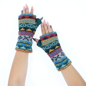 May include: A pair of fingerless gloves featuring a multi-colored knit pattern with horizontal bands of teal, mustard yellow, red, and grey. The gloves have a ribbed cuff at the thumb opening and a textured, chunky knit construction throughout the design.