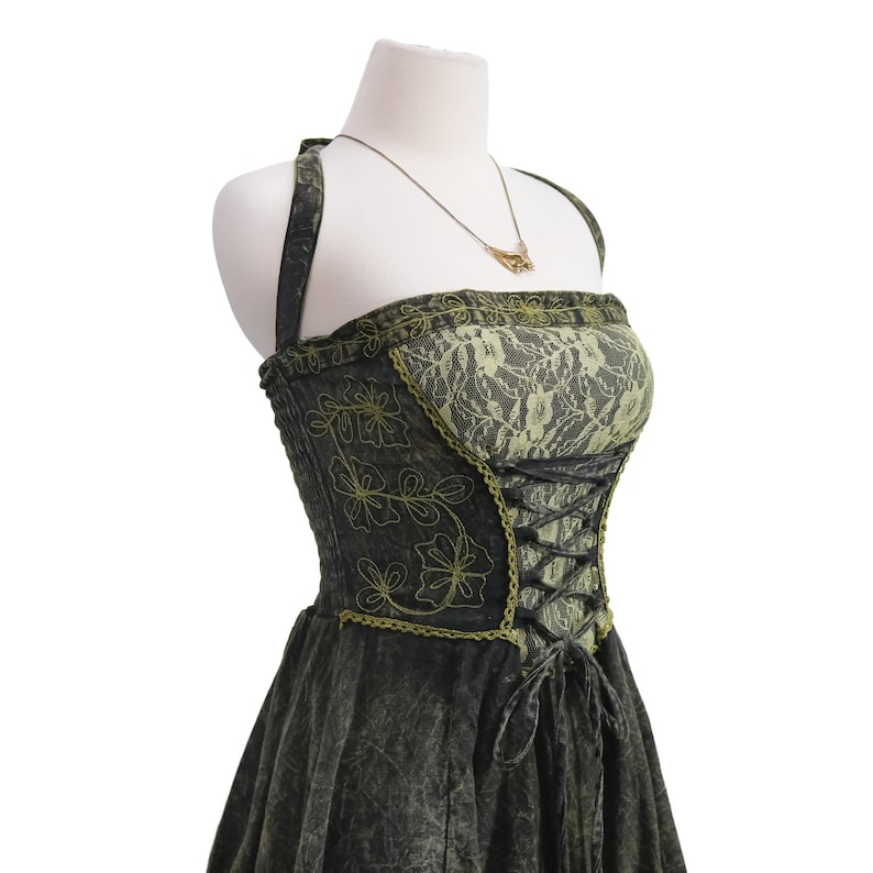 May include: A dark charcoal gray halter dress featuring a lime green lace bodice overlay, black corset-style lace-up front detailing, and lime green floral embroidery on the sides. The garment includes a thin gold-toned necklace with a pendant.