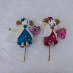 May include: Two felt mouse ornaments with white coats, blue and pink dresses, and carrying small red gift boxes.