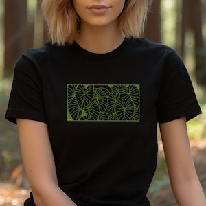 May include: A black t-shirt with a green graphic print of a cluster of large leaves.