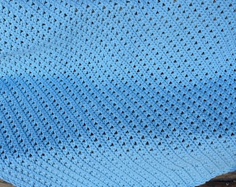 May include: A light blue crocheted baby blanket with a delicate stitch pattern.