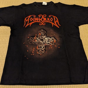 May include: Black t-shirt with a red and white graphic of a cross with the band name "MOONSPELL" printed above it.