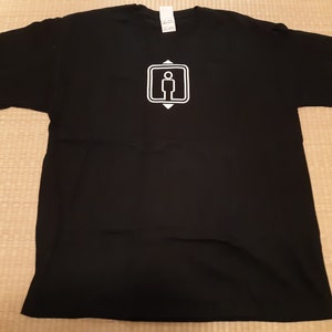 May include: Black t-shirt with a white graphic of a person standing inside a square with arrows pointing up and down.