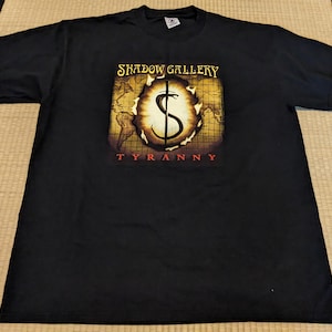 May include: Black t-shirt with a graphic print of a snake and the text "Shadow Gallery Tyranny".