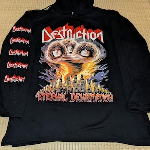 May include: Black long-sleeved hooded top with a graphic print of a band called "Destruction" and the text "Eternal Devastation". The sleeves have the band's name repeated down the side.