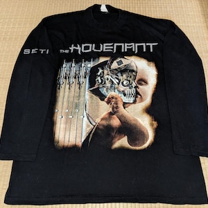 May include: Black long-sleeved t-shirt with a graphic print of a baby with a robotic head. The text "SETI THE" and "HOUELPAHT" are printed on the shirt.