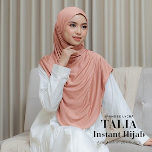May include: A solid dusty rose coloured instant hijab made of spandex lycra fabric. The text on the image reads: SPANDEX LYCRA TALIA Instant Hijab Available in 20+ Colors. The head covering drapes over the shoulders and chest in a smooth finish.