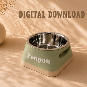 Puede incluir: Un cuenco para mascotas de color verde salvia con interior de acero inoxidable y base beige. La palabra Ponpon está impresa en blanco en el lateral. El texto DIGITAL DOWNLOAD es visible sobre el cuenco. Tiene asas laterales integradas.