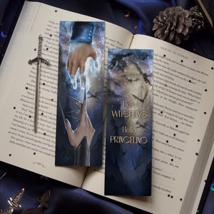 Op de afbeelding: Twee bladwijzers met een fantasie thema. De eerste bladwijzer toont een hand die met een gloeiend licht reikt. De tweede bladwijzer toont een donker bos met een silhouet van een draak en de tekst "Hello Witchling Hello Princeing".