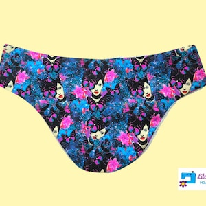 Peut inclure: Sous-vêtements noirs et bleus avec un imprimé coloré de papillons et de visages de femmes. L'imprimé a un fond de type galaxie.