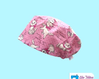 Può includere: Cappellino chirurgico rosa con un motivo ripetuto di gatti bianchi dei cartoni animati con fiocchi rosa, con la scritta "Je T'aime Paris". Il cappellino è in tessuto e ha una forma arrotondata.