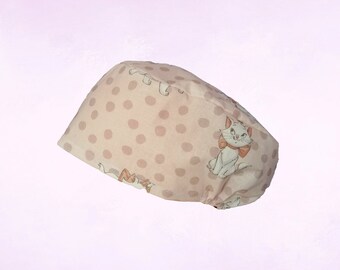 Può includere: Un cappello da scrub rosa e bianco con un motivo a pois e un design di gatto dei cartoni animati. Il cappello ha un elastico bianco.