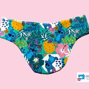May include: Green, blue, and yellow patterned underwear with a cartoon character print. The character is blue with two large ears and a big smile. The text "Lilo Telitas Hand Made" is visible in the bottom right corner.