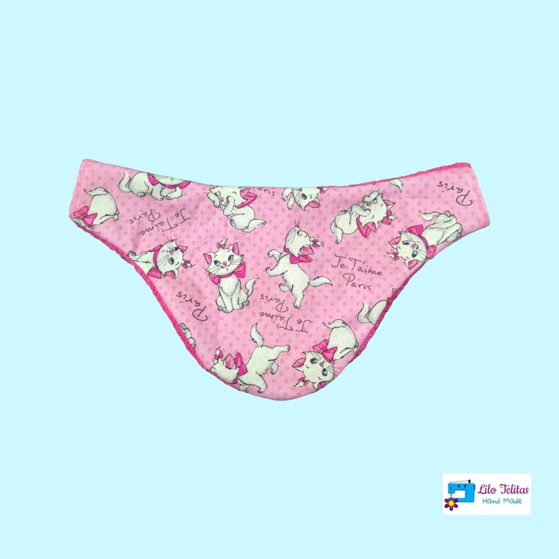 K&ouml;nnte beinhalten: Rosa Stoff-Babyspucktuch mit wei&szlig;em Rand und einem sich wiederholenden Muster aus wei&szlig;en Katzen mit rosa Schleifen und dem Text "Je Taime Paris".