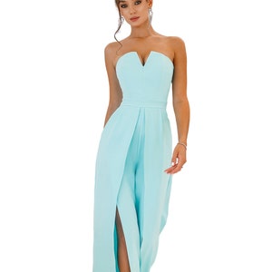 May include: A light blue strapless jumpsuit with a V-neckline and a side slit. The jumpsuit has a fitted bodice and wide legs.