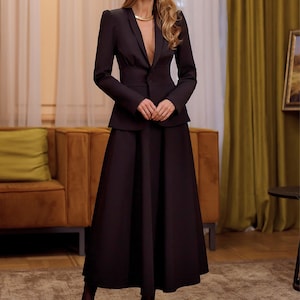 Traje de falda negro discreto, conjunto de blazer entallado y falda larga para mujer.