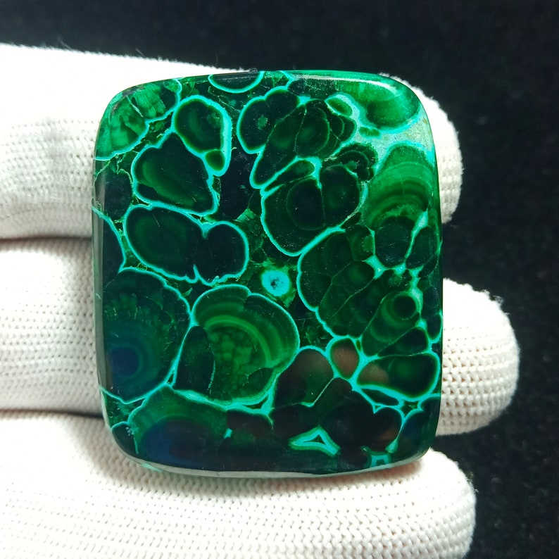 May include: A square-shaped green malachite cabochon with a swirling, concentric pattern. The stone has a dark green color with lighter green accents.