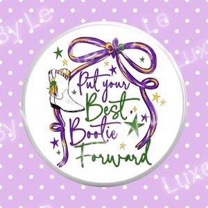 May include: A round white button with a purple and gold ribbon design and the text "Put your Best Bootie Forward". The button features a white cowboy boot with a yellow tassel and green and gold stars.