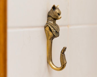 Wall hook in the shape of a cat in armor. Sturdy brass wall hanger for the bathroom, children's room, or backpack hook.