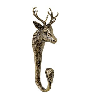 Könnte beinhalten: Ein bronzefarbener Wandhaken in Form eines Hirschkopfes. Der Haken hat detaillierte Geweihe, ein strukturiertes Gesicht und einen gebogenen Haken am unteren Ende. Der Haken ist zum Aufhängen von Gegenständen gedacht und verleiht jedem Raum einen rustikalen Touch.