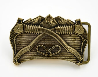 Alpinist Belt Buckle - Brass buckle featuring images of mountains and alpine gear.