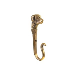 May include: A gold-toned metal hook with a dog's head sculpted at the top. The hook is curved and has a small hole near the top.