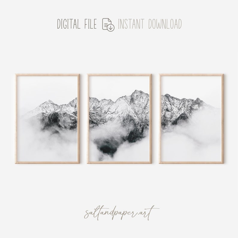 May include: Three black and white photographs of a mountain range with snow-capped peaks partially obscured by clouds. The photos are framed in natural wood frames.
