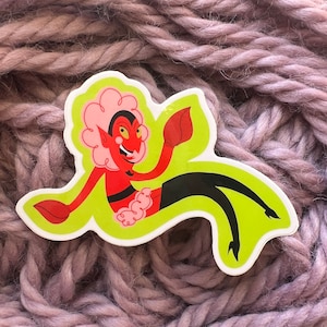 May include: A red and black cartoon devil character with pink hair and a green background. The character is wearing a black dress and has a mischievous expression.