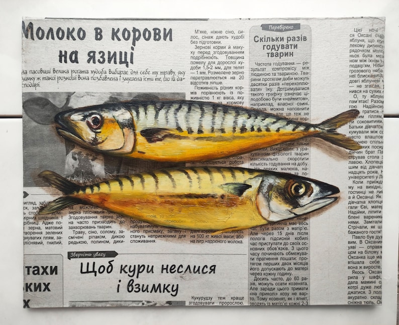 May include: An oil painting on canvas depicts two yellow and brown mackerel fish, with dark stripes, lying on a newspaper background. The newspaper text is in Ukrainian. The fish are painted with realistic detail.