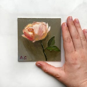 May include: A small painting of a single pink flower with green leaves on a gray background. The painting is signed "B.O."