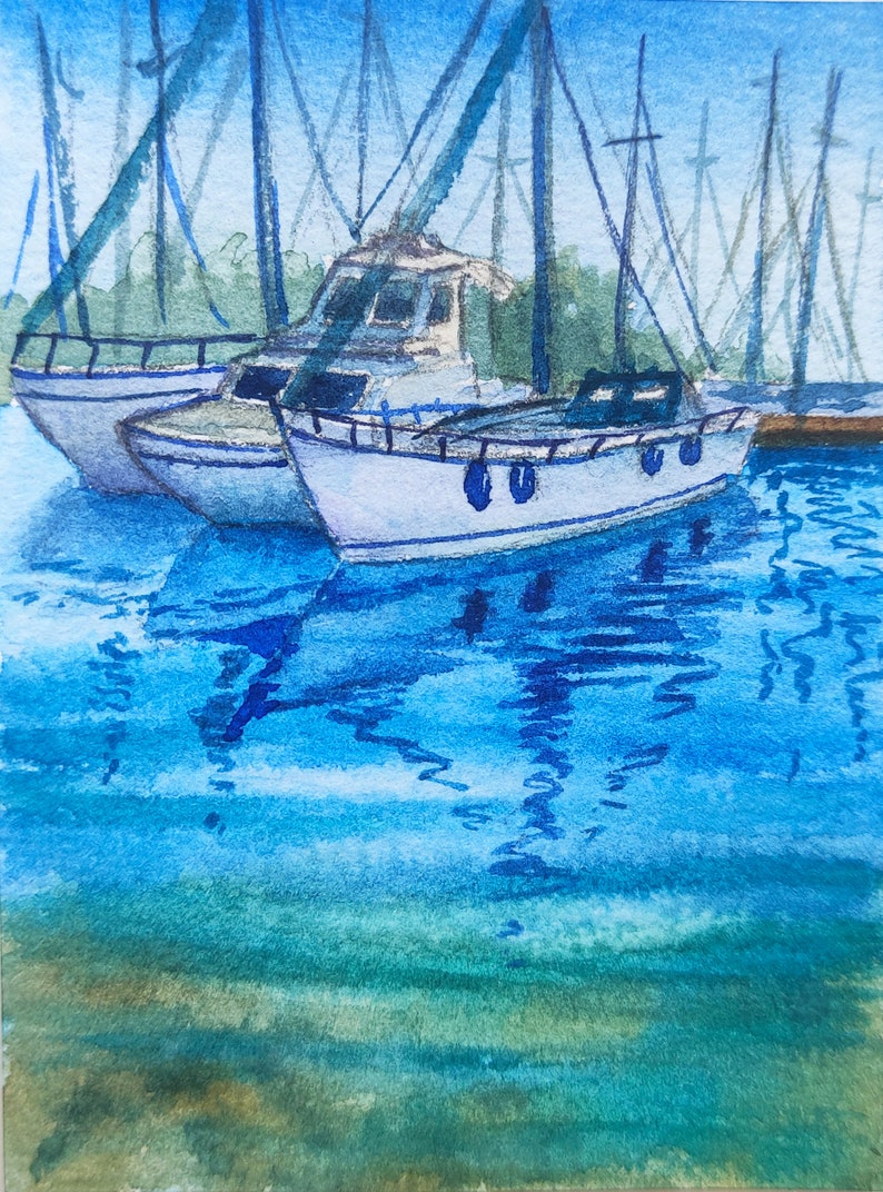 Puede incluir: Una pintura de acuarela de un velero azul y blanco atracado en un puerto. El agua es de color azul claro con ondas azules m&aacute;s oscuras. El cielo es de color azul claro con nubes blancas.