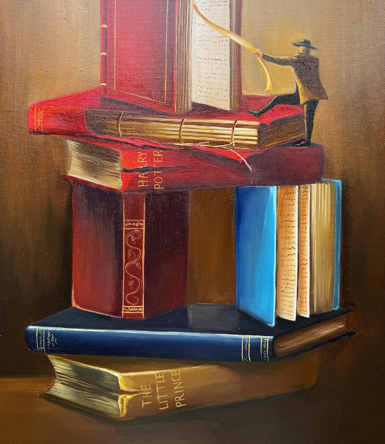 May include: A stack of books with red, blue, and gold covers. The top book has the title "Harry Potter" on the spine. A small figure in a brown coat and hat is standing on top of the books, holding a yellow ribbon.