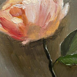 May include: A single, pale pink flower with a yellow center, painted in a loose, impressionistic style. The flower is on a stem with a single green leaf. The background is a muted gray.